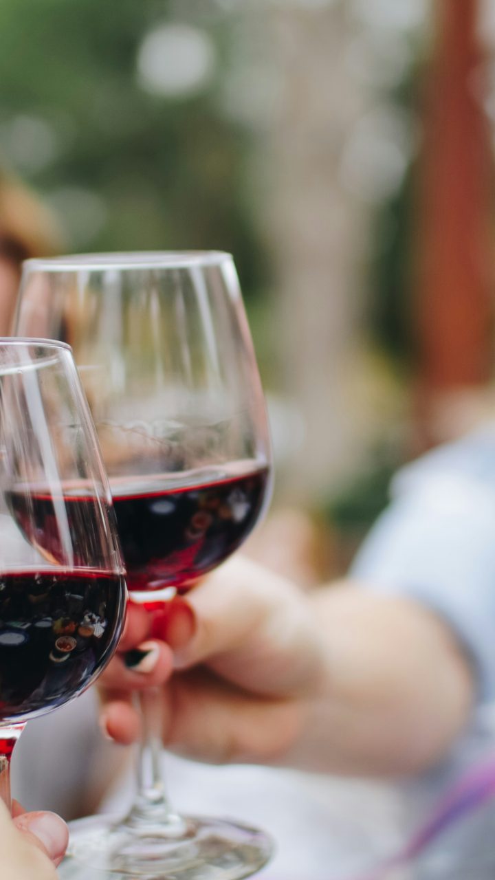 people tossing their clear wine glasses